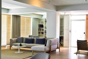 a living room with a couch and a table and chairs at Aqualuz Lagos by The Editory in Lagos
