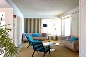 a living room with blue chairs and a couch at Aqualuz Lagos by The Editory in Lagos