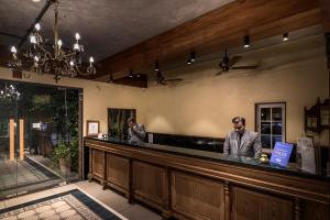 two men standing at the bar of a restaurant at Budget Inn Bellevue in Surat