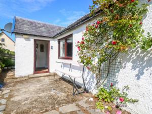 a bench sitting in front of a house with a bush at 2 Tougal in Mallaig