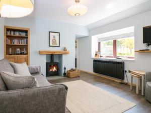 a living room with a couch and a fireplace at 2 Tougal in Mallaig