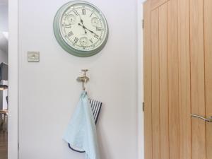 a clock hanging on a wall next to a door at 2 Tougal in Mallaig