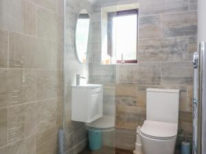 a bathroom with a toilet and a sink and a window at 2 Tougal in Mallaig
