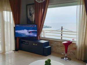 a living room with a flat screen tv and a window at Luxury Seaside House in Mades Heraklion in Agia Pelagia