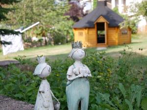 two statues of cats and a bird house in a garden at Haus Camino in Löffingen