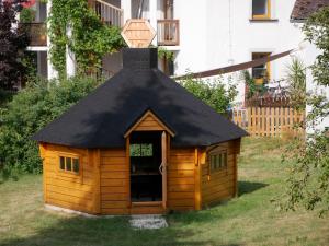 a large wooden dog house with a black roof at Haus Camino in Löffingen