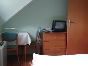a room with a table and a tv on a dresser at Rooms Hochkraut in Celje