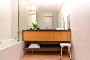a bathroom with a sink and a mirror and a stool at Aqualuz Lagos by The Editory in Lagos