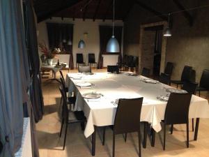 een grote eetkamer met een witte tafel en stoelen bij La Locanda in Calvignano