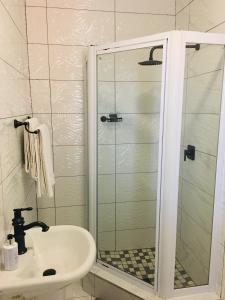a bathroom with a shower, sink, and toilet at Riverton Manor in Centurion