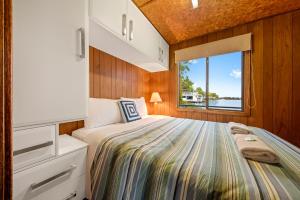 a small bedroom with a bed and a window at Renmark River Villas and Boats & Bedzzz in Renmark +92 photos