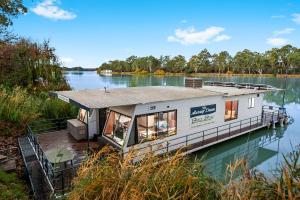a tiny house on a dock on a lake at Renmark River Villas and Boats & Bedzzz in Renmark