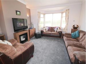 a living room with couches and a flat screen tv at 53 Burniston Road in Scarborough