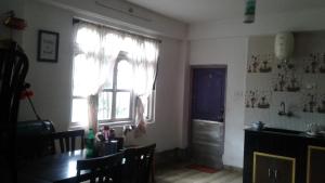 a dining room with a table and a window at Yakchiri Homestay in Tādong
