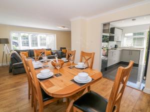 a dining room and living room with a wooden table and chairs at Croeso in Cemaes Bay