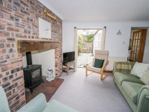 sala de estar con pared de ladrillo y chimenea en Bryn Haf, New Street, en Beaumaris