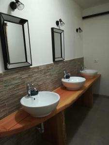 two sinks on a wooden counter with two mirrors at CASA DELLE GUARDIE Rifugio in Madonna di Fornelli