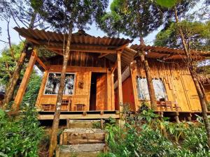 Sapa Jungle Homestay في سابا: كابينة خشبية في الغابة مع شرفة