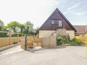 a wooden fence in front of a house at Stable Loft in Winscombe