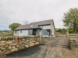 una casa con un muro de piedra y una valla en Llwyd Coed Canol, en Caernarfon