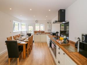 Una cocina con una mesa de madera y un comedor. en Llwyd Coed Canol, en Caernarfon