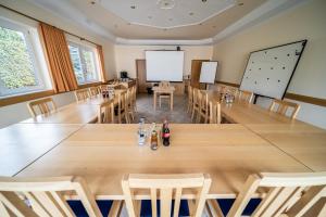 ein Konferenzraum mit einem großen Holztisch und Stühlen in der Unterkunft Hotel Rieder in Wiesemscheid