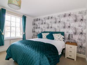een slaapkamer met een bed met een blauw dekbed bij The Hoist in Ely
