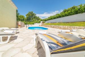 eine Terrasse mit Liegestühlen und einem Pool in der Unterkunft Holiday Home Tina in Cavtat