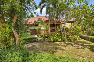 a house in the middle of a yard with trees at Pinnacle Samui Resort in Mae Nam