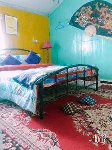 1 dormitorio con 1 cama grande y alfombra roja en Vamoose Quaint Wood Cottage, en Darjeeling