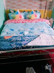 a bed with a blue comforter and pillows at Vamoose Quaint Wood Cottage in Darjeeling