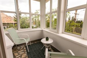 a room with windows and a table and chairs at Casa Bella WHC in Cluj-Napoca