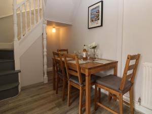 a dining room with a wooden table and chairs at Harbourside Cottage in Torquay +18 photos