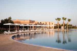 a swimming pool with chairs and umbrellas in a resort at Marrakech Ryads Parc All inclusive in Marrakech