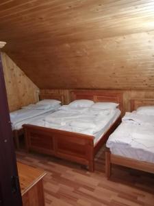 two twin beds in a wooden cabin at Deea Cascada in Vidra
