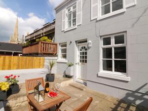 a patio with a table and chairs and a building at Harbourside Cottage in Torquay