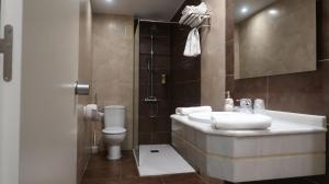 Hotel Teruel Plaza في تيرويل: حمام مع حوض ومرحاض