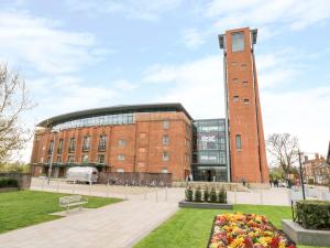 ein Backsteingebäude mit einem Uhrturm davor in der Unterkunft Midsummer Cottage in Stratford-upon-Avon