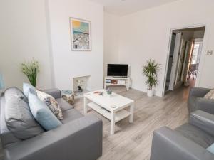 ein Wohnzimmer mit Sofa und Tisch in der Unterkunft Midsummer Cottage in Stratford-upon-Avon