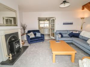 a living room with blue furniture and a fireplace at 1 The Moorings in Newry