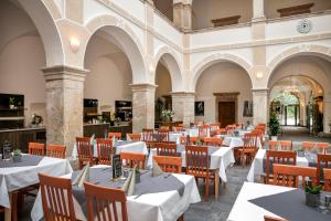 an empty restaurant with white tables and chairs at JUFA Hotel Schloss Röthelstein in Admont