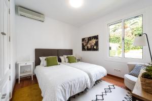 a white bedroom with a large bed and a window at LAS HORTENSIAS WITH PRIVATE POOL in Santa Brígida +54 photos