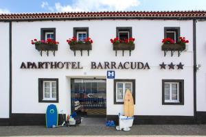 a white building with a surfboard in front of it at Aparthotel Barracuda in Ponta Delgada