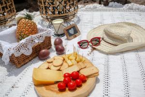 a table topped with a plate of cheese and fruit at Aparthotel Barracuda in Ponta Delgada