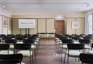 a room with rows of chairs and a projection screen at H10 Casa de la Plata in Seville