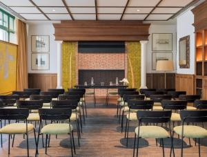 a room with chairs and a table and a fireplace at H10 Casa de la Plata in Seville