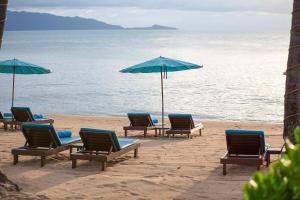 a group of chairs and umbrellas on a beach at Pinnacle Samui Resort in Mae Nam