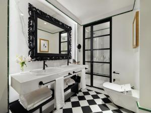 a bathroom with a sink, mirror, and bathtub at H10 Casa de la Plata in Seville