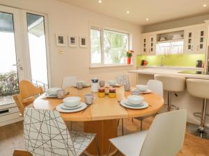 cocina y comedor con mesa de madera y sillas en Bay View Cottage en Newport-On-Tay