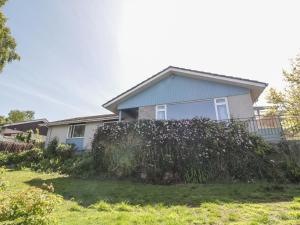 una casa con una siepe davanti di Bay View Cottage a Newport-On-Tay